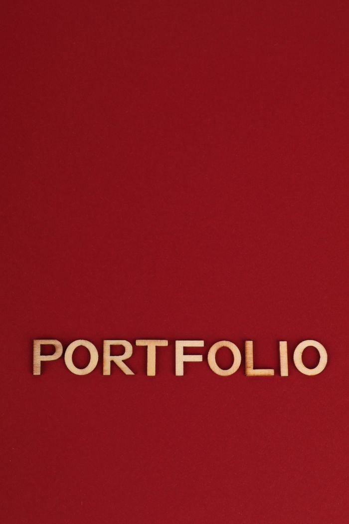 Wooden text spelling PORTFOLIO on a bold red background, ideal for design and business themes.